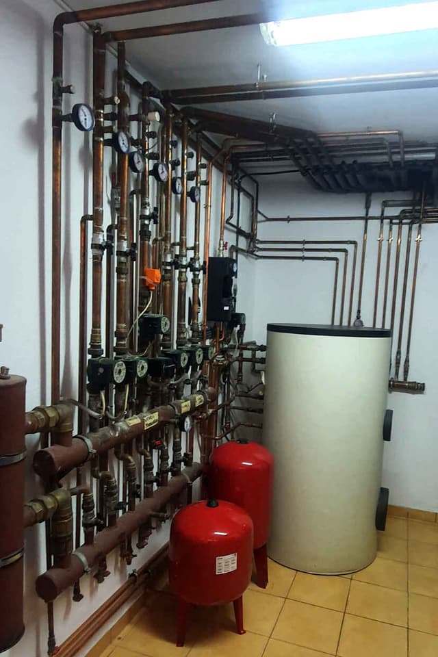 Heating pipework arranged around hot-water storage equipment